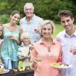 Portrait of happy multi-generation family enjoying barbecue and wine
