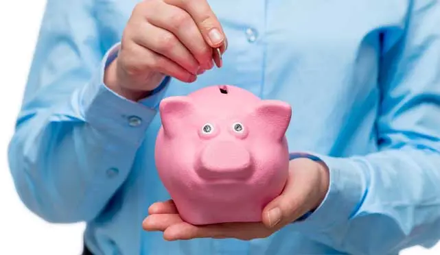 man with piggybank and putting the money inside